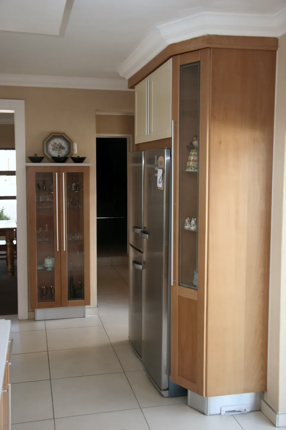 Tall fridge housing beside a glazed pantry unit