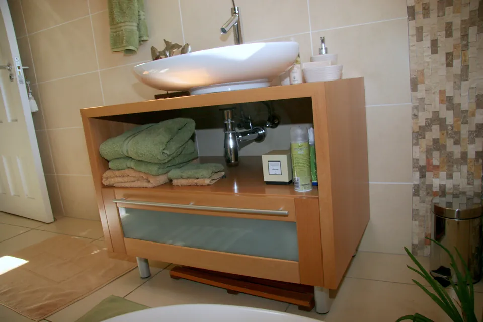 Open vanity with a vessel basin and a towel shelf