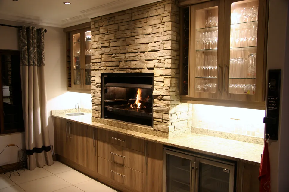 The braai wall from the side, with the fire lit