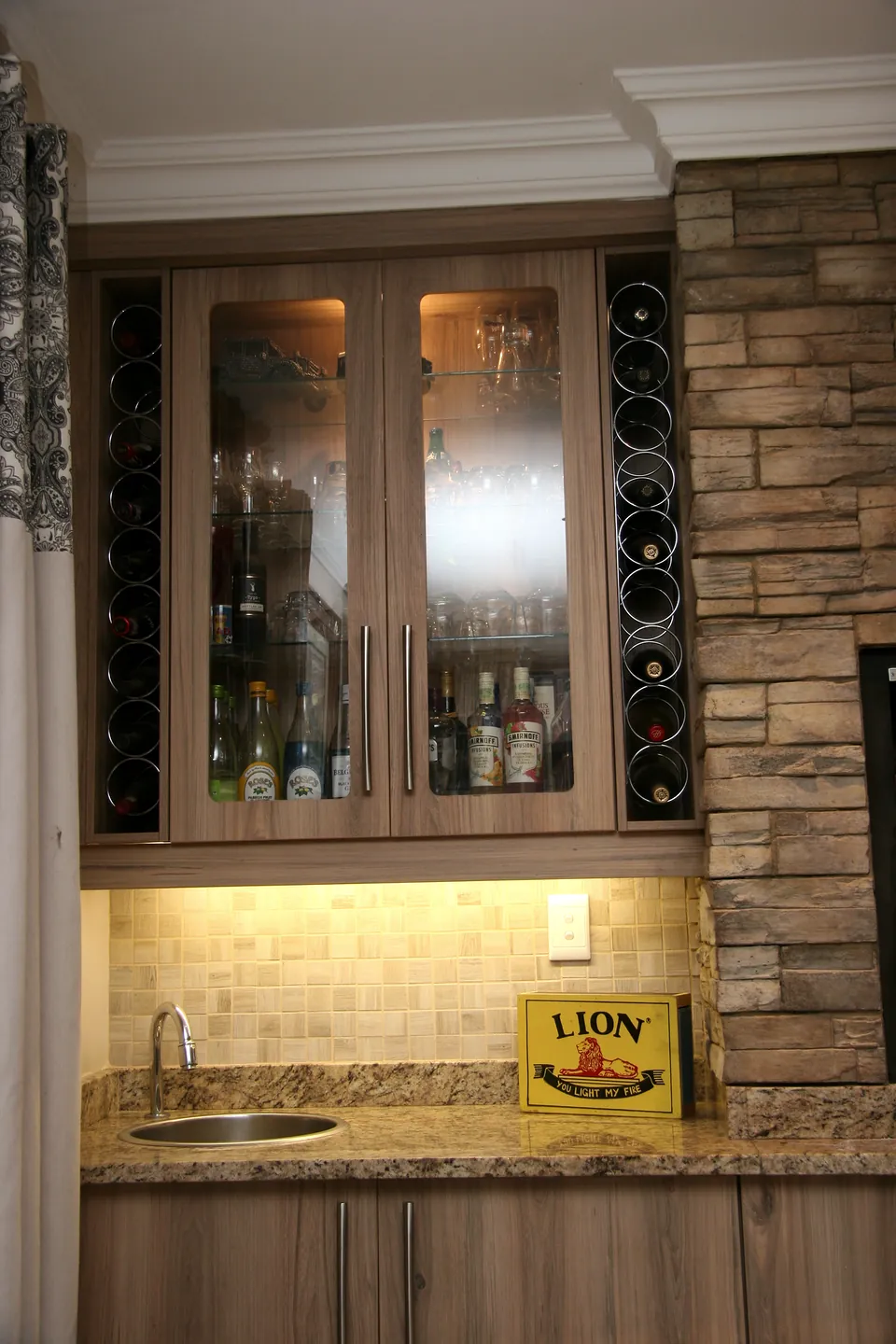 Glazed bar cabinet with wine storage beside the chimney breast