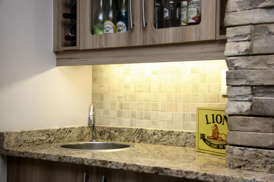 Bar sink under a lit glazed cabinet