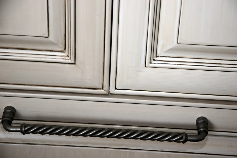 Twisted iron handle on a raised-panel drawer
