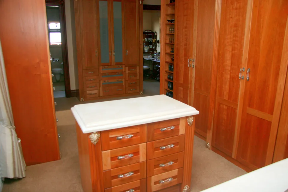 Dressing island with a stone top in front of the wardrobes