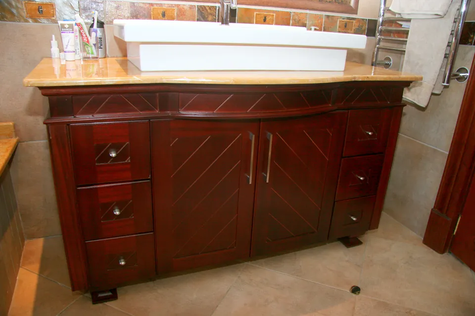 Mahogany vanity with herringbone doors and a vessel basin