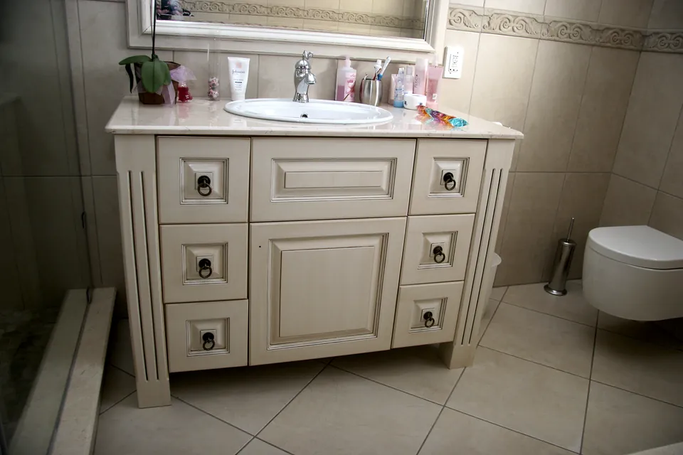 Painted country-style vanity with raised panels and ring pulls