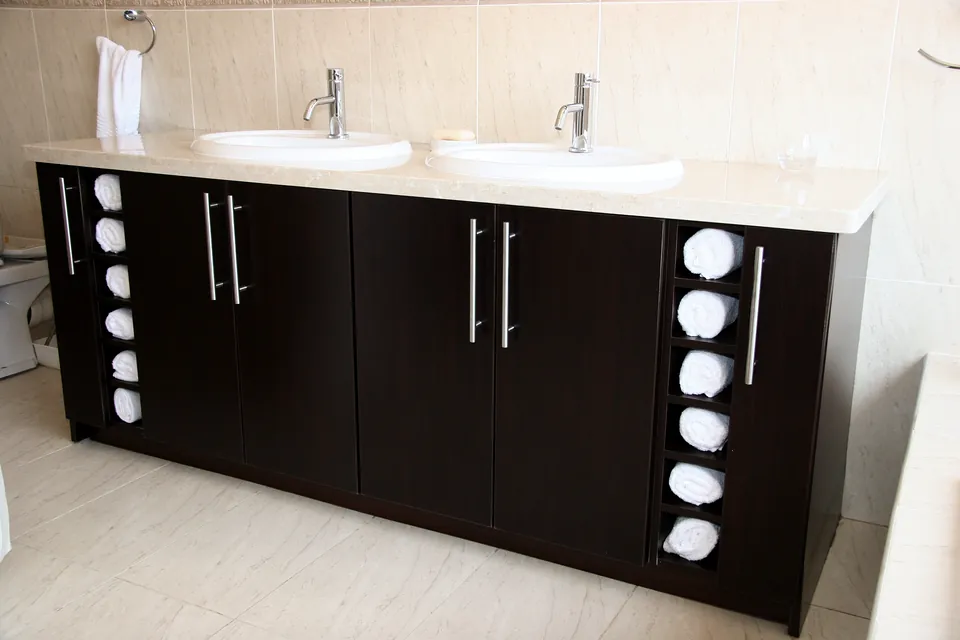 Double vanity in a dark finish with towel cubbies at each end