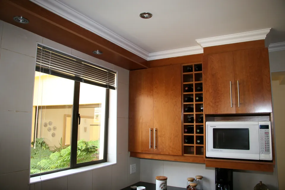 Wine rack and microwave housing beside the window