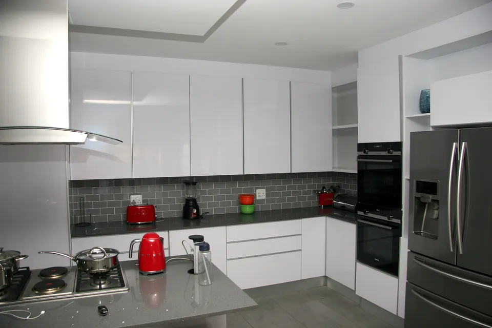 L-shaped run with handleless drawers and an oven tower