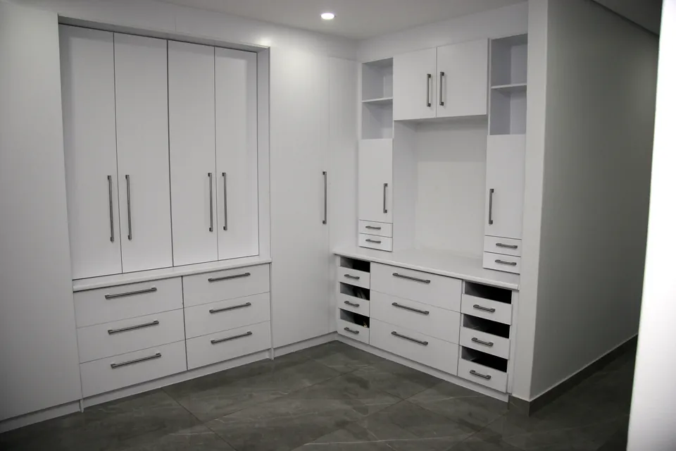 White built-in cupboards with a drawer bank and dressing table